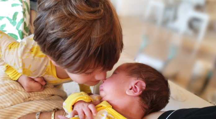 A Baby Over 40?! Here We Go Image: A little boy looks lovingly at his newborn brother