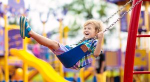 Image: A little boy swinging on a swing at a playground