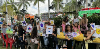Image: Children at Miami Mom Collective's Comic Kids event hold up pictures of their squish mallows