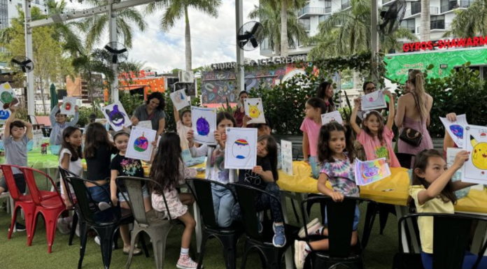 Image: Children at Miami Mom Collective's Comic Kids event hold up pictures of their squish mallows