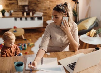 Image: A mom working from home while her toddler plays beside her