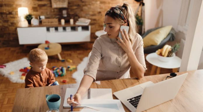 Declutter Your Workspace: 3 Spring Cleaning Tips Image: A mom working from home while her toddler plays beside her