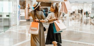 Image: 2 women carrying shopping bags while they shop together