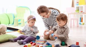 Image: A babysitter watches two toddlers playing