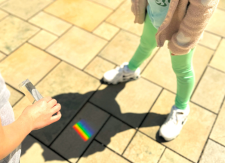 Embracing Neurodiversity: Celebrating Autism Acceptance Month Image: Students use a prism outdoors to cast a rainbow on stone pavers