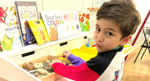 Image: A young child plays with a sensory bin at a local learning center