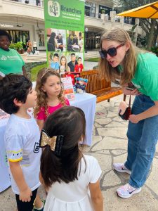 Image: Three children speak with a representative from Branches, a local nonprofit