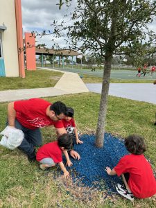 Image: Three kids participating in a local service project with their dad