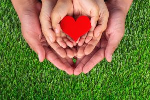 Image: Three sets of hands holding a red heart