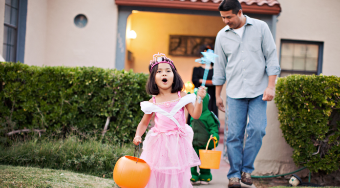 Trick-or-Treating: How It Became an American Tradition | Dr. Bob Image: A little girl trick-or-treating with her dad