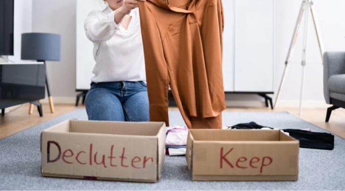 Cleaning and Donating: Give Back Through Decluttering Image: A woman sorts clothing into boxes labeled "declutter" and "keep" as a way to give back