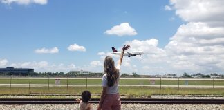 Image: A mother and son wave to an airplane as it lands at MIA