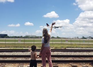 Summer Activities: 5 Different Things to Try With Kids in Miami Image: A mother and son wave to an airplane as it lands at MIA