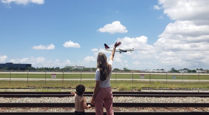 Summer Activities: 5 Different Things to Try With Kids in Miami Image: A mother and son wave to an airplane as it lands at MIA