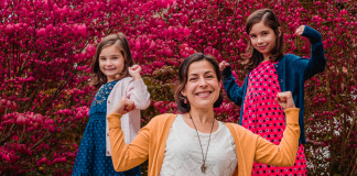 Image: A mom strikes a strong pose with her daughters