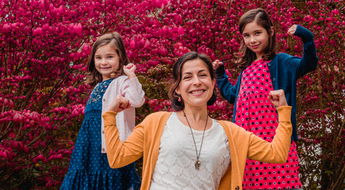 Investing in Yourself & Our Planet | MOM STRONG Image: A mom strikes a strong pose with her daughters