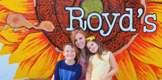 Image: Two kids and a mom sitting on a haystack at Royd's