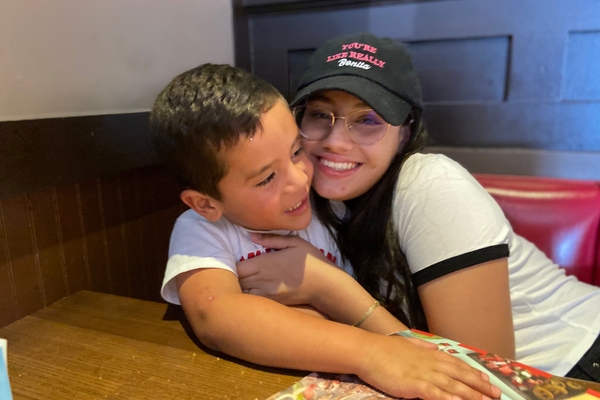 Image: A brother and sister sit together at a restaurant