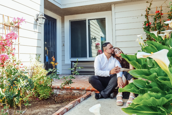 Image: A couple sitting on the front step of a nicely landscaped entryway