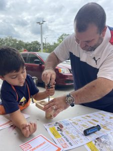 Image: A father and son work on a building project at a Home Depot workshop for kids