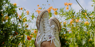 Image: Crossed ankles in a field of flowers