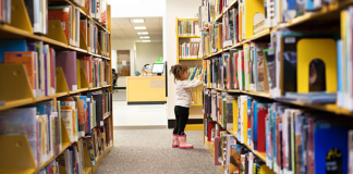 Image: A little girl peruses books at a library
