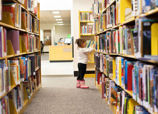 Read Across America: 5 Ways to Get Kids Excited About Reading Image: A little girl peruses books at a library