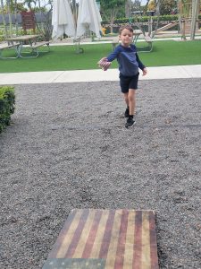 Image: A boy playing cornhole at Royd's