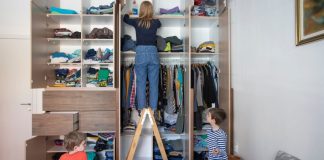 De-Clutter Your Home With These 4 Simple Organization Tips Image: A mom organizes a room while her children play