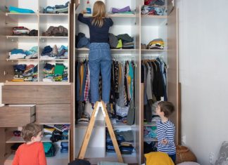 De-Clutter Your Home With These 4 Simple Organization Tips Image: A mom organizes a room while her children play