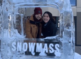 A couple poses for a picture in at ice sculpture in Snowmass, CO