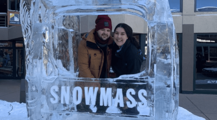 A couple poses for a picture in at ice sculpture in Snowmass, CO