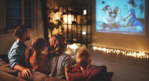 Image: A family sitting on the couch, watching a movie together