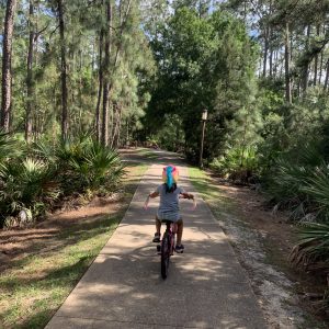 Rachelle's daughter rides her bike through the woods