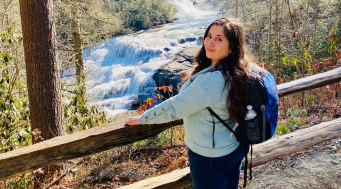 Fall Getaways: 8 Destinations to Visit This Year MMC Contributor Rachel Santos at a waterfall in Asheville, NC