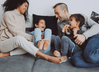 A Thank You to the Partner Who Carries Their Weight in Parenting A family hanging out a laughing together