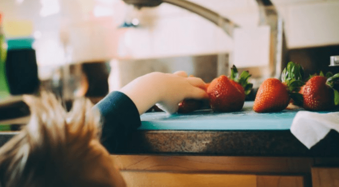 Creating Healthy Food Habits for Babies + Children A toddler reaches to grab some fresh fruit