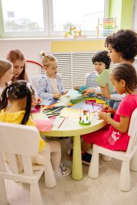 A small group of children working on an art lesson with their teacher