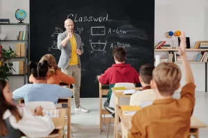 A teacher calling on a student who's raising his hand