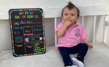The First Day of School: 5 Helpful Tips For Preparing Your Child A toddler sits next to a My First Day of School board