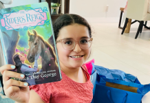 An almost middle school student holding up a new book