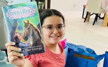 An almost middle school student holding up a new book