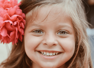 Common Pediatric Dental Procedures, Part 2 | Dr. Bob Pediatric Dentist A little girl with a flower in her hair, showing off her smile