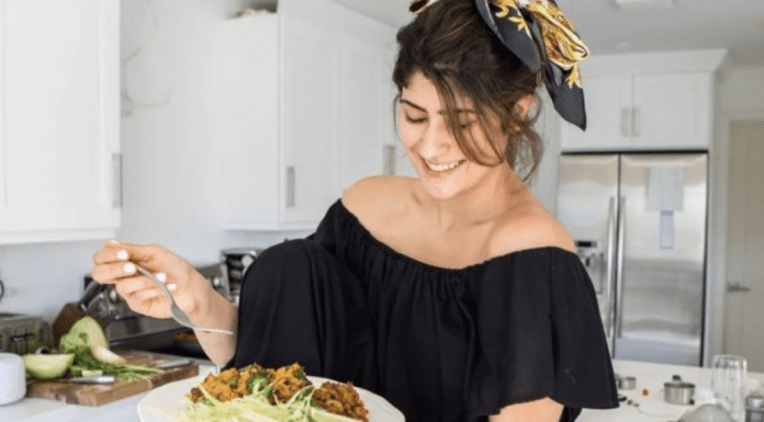 Arroz Con Gandules: A Seasonal Dish With a Twist Michele holding a plate of homemade arroz con gandules