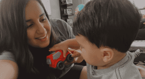 Daniella and Enzo playing with a red car.