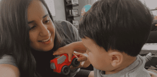 Daniella and Enzo playing with a red car.