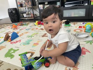 A little boy sitting on the floor with a toy