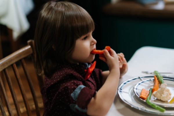 A little boy enjoys some veggies at a local restaurant
