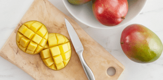 Image: A sliced mango on a wooden cutting board