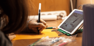 Communication: 7 Conversation Starters For Kids A child sitting in front of a tablet at a table, writing with a marker